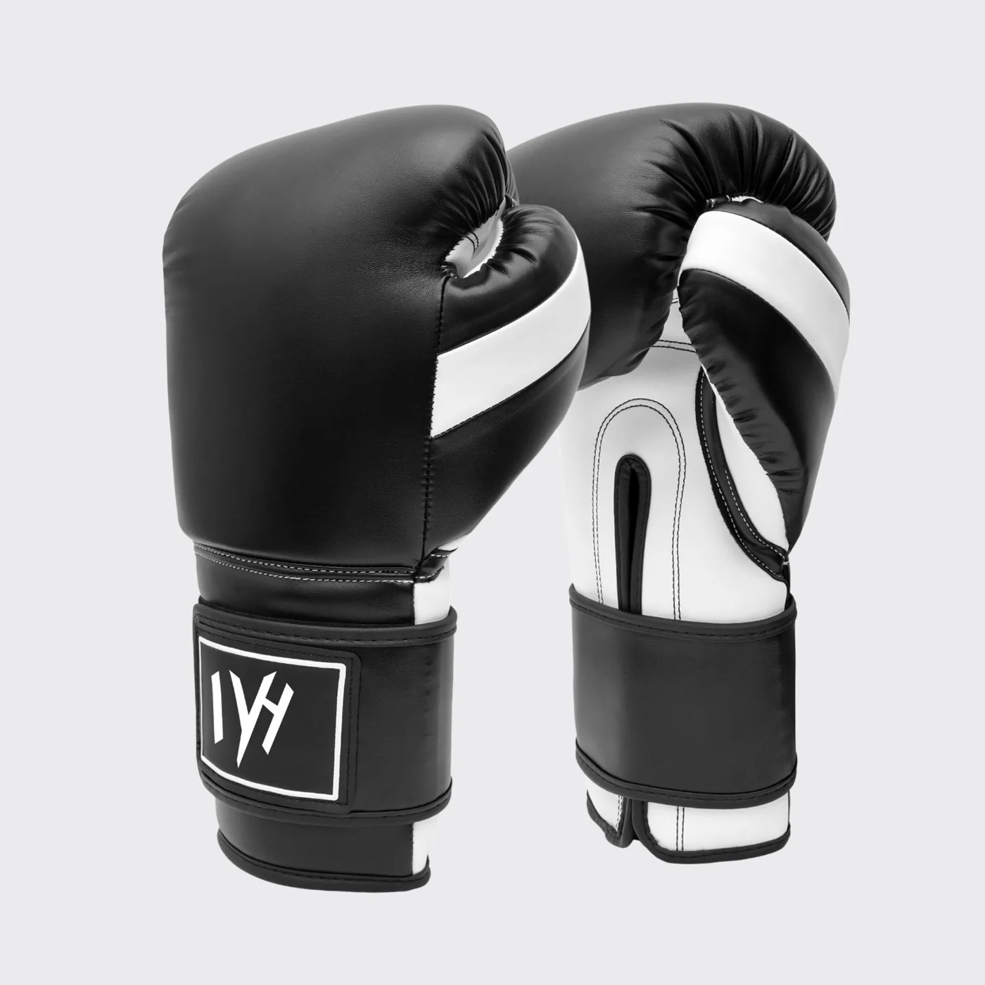 mayhm premium boxing gloves Angled view of MAYHM Premium Boxing Gloves in black and white with reinforced wrist support and shock-absorbing padding for boxing training and sparring.